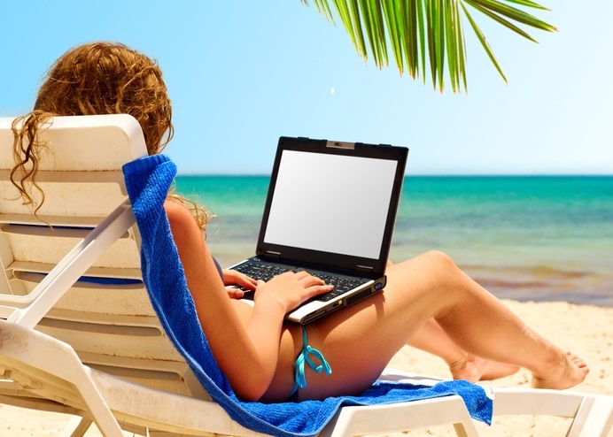 surfing on the beach. Laptop display is cut with clipping path